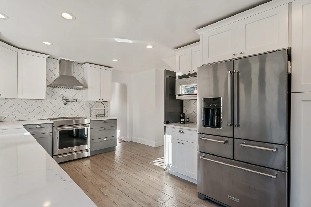 Bright modern kitchen — Custom cabinetry, herringbone tile, integrated appliances