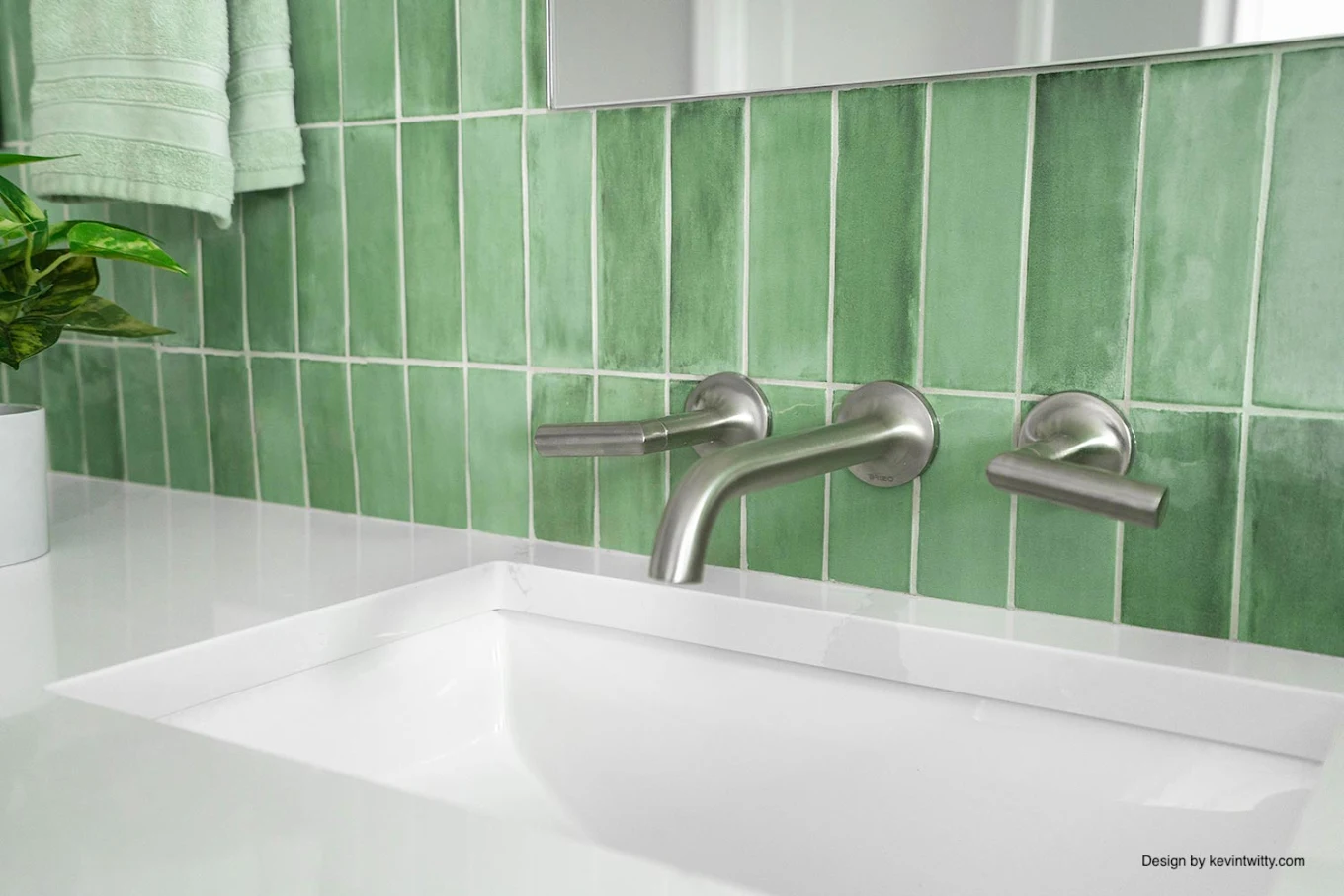 Brushed nickel wall-mount faucet against green stack tile