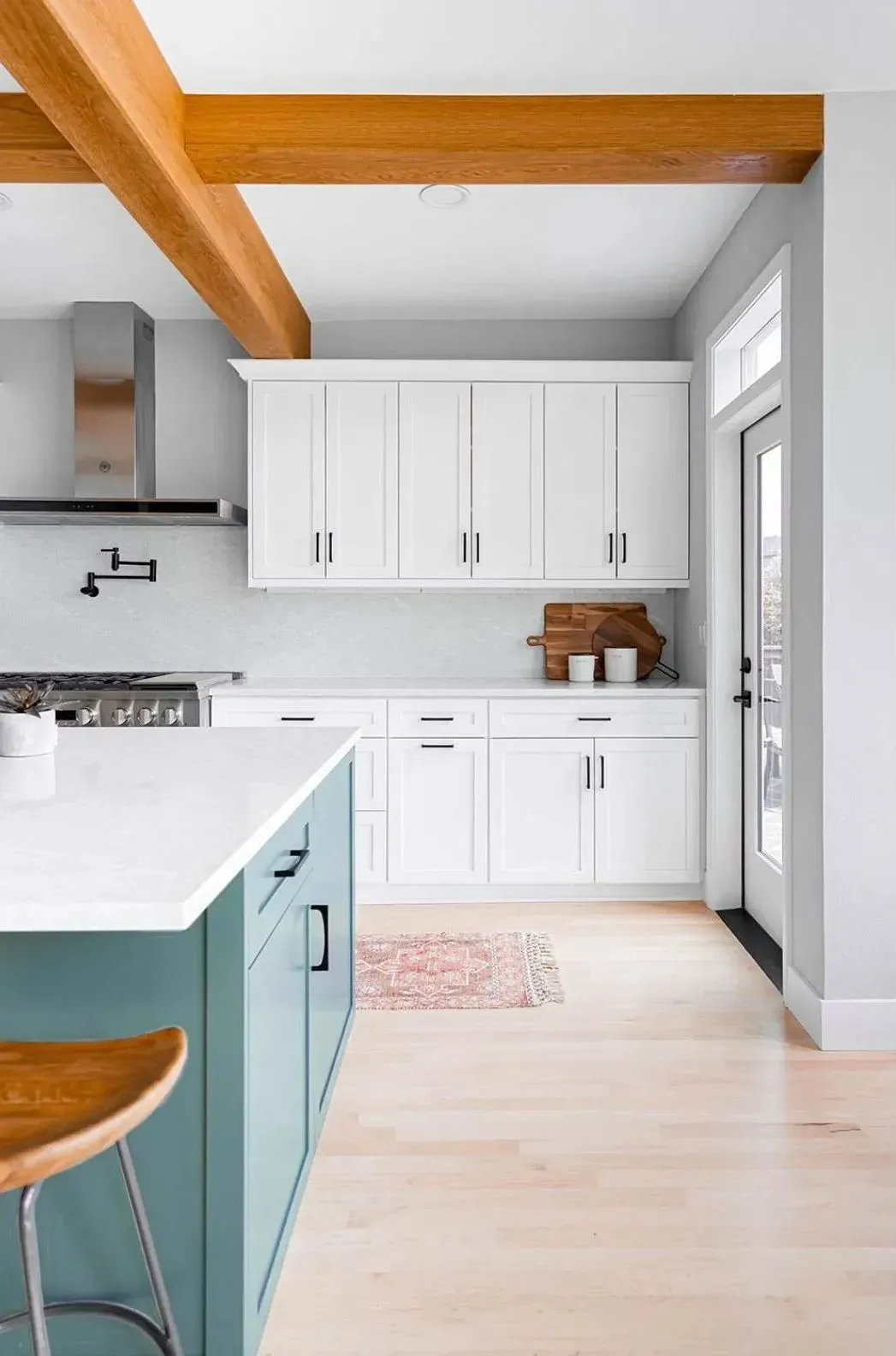 Bethany kitchen with white cabinets, teal blue island, exposed wood beams