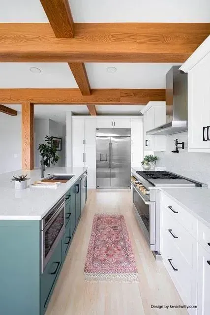 White kitchen with stainless French-door fridge and range wall under exposed beams