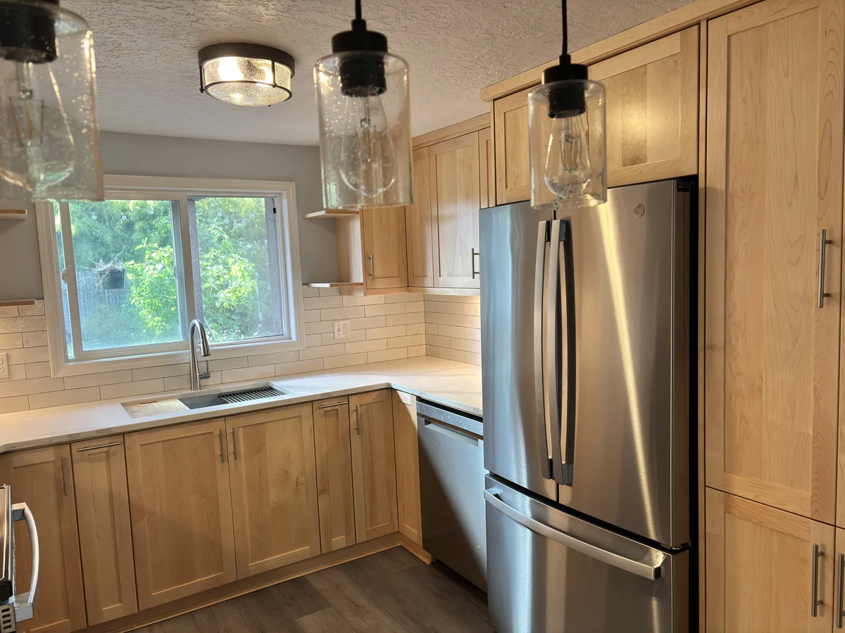 Sink run with the window, open shelves, dishwasher, refrigerator, and pantry column