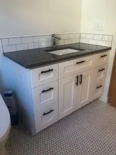 Bath vanity with white subway tile and hex floor