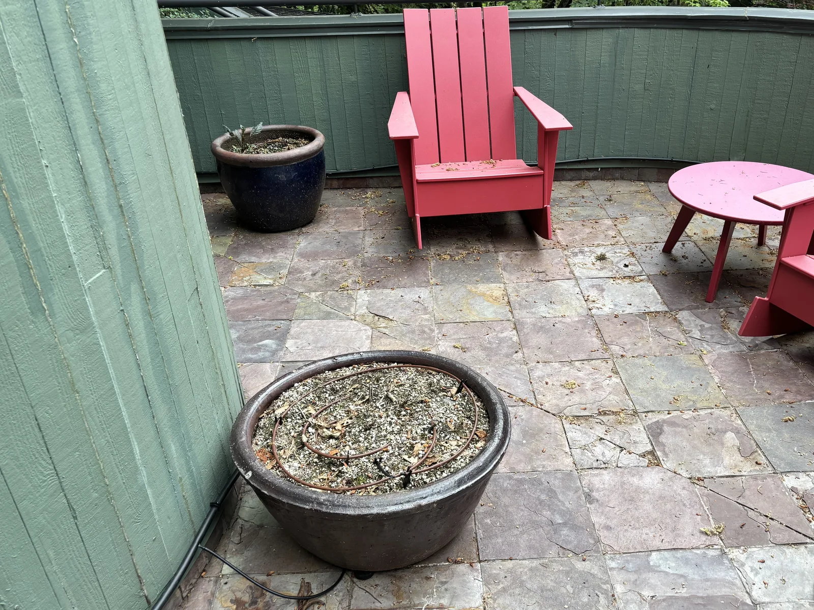 The deck before, slate tile over the garage with red chairs