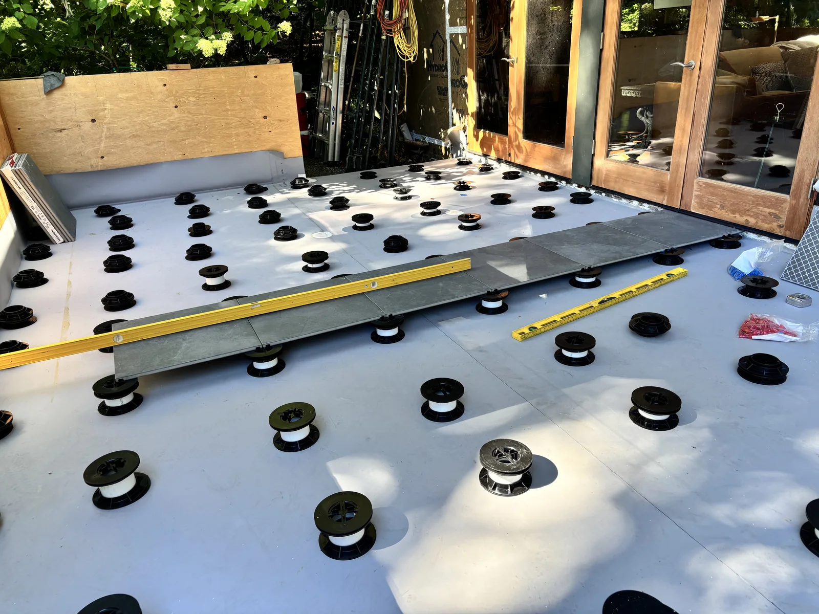 Pedestals set on the sealed membrane before the pavers