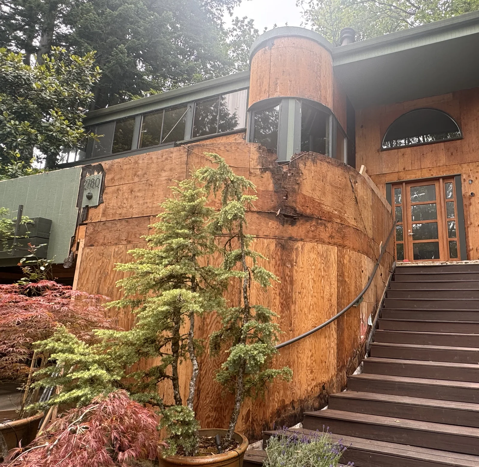 The front of the house stripped to the sheathing with the railing rebuilt